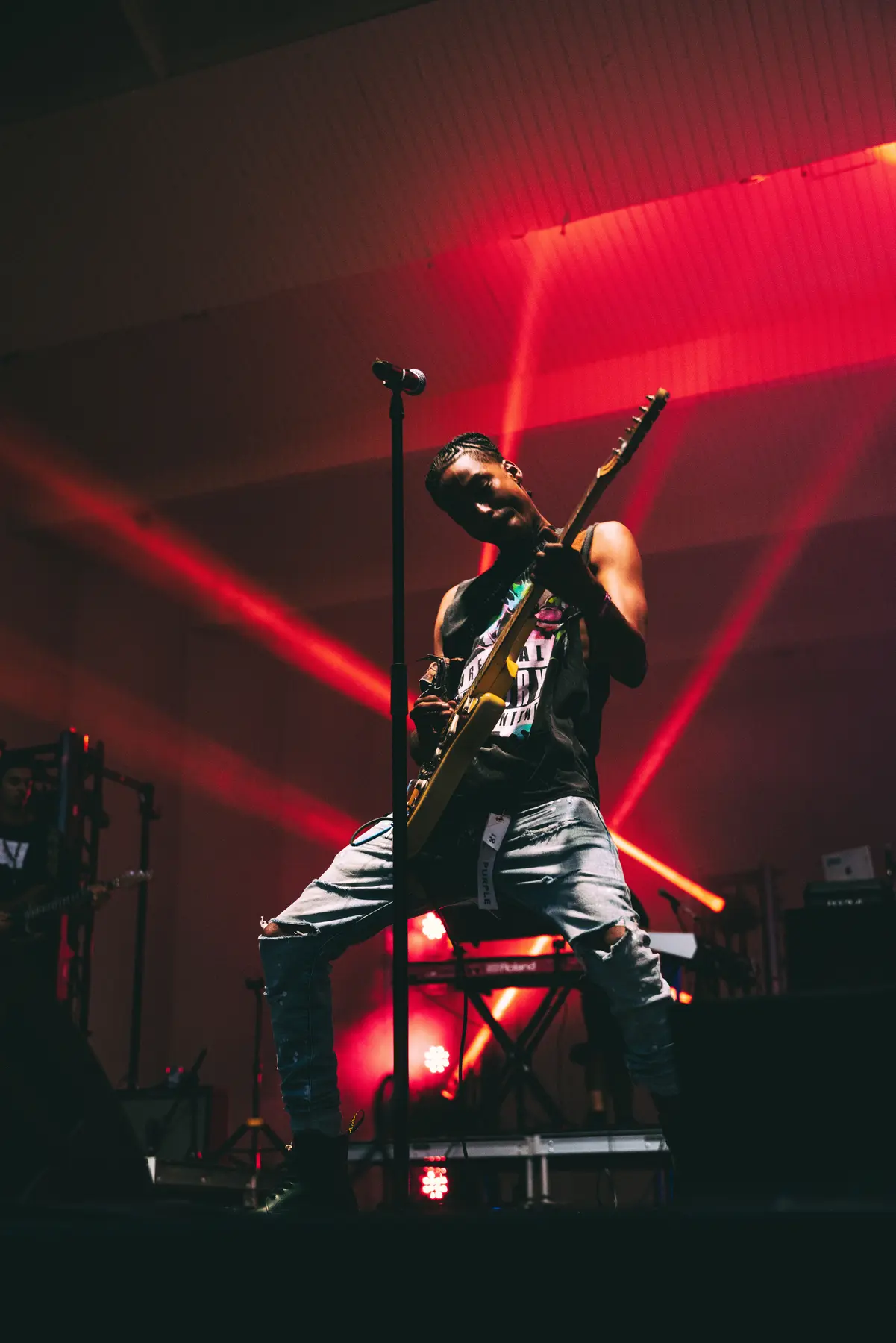 JDR leaning into a guitar solo under red concert lights